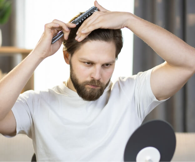 handsome-bearded-man-combs-his-hair-looking-in-the-2024-12-13-12-23-49-utc